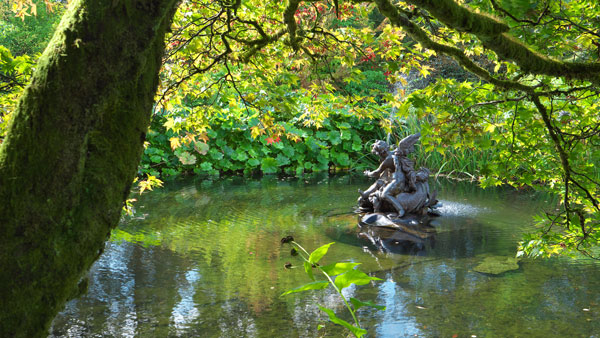 sculpture on pond surrounded by lush greenery serene nature scene with reflections water element 2 tranquility 2 beauty